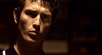 Movie still from “Lock, Stock and Two Smoking Barrels” (1998), directed by Guy Ritchie – A man's face in a dark room; Close Up shot, Low angle