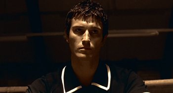 Movie still from “Lock, Stock and Two Smoking Barrels” (1998), directed by Guy Ritchie – A man with a black shirt and a white collar; Close Up shot, Low angle