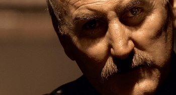 Movie still from “Lock, Stock and Two Smoking Barrels” (1998), directed by Guy Ritchie – An old man with a mustache and a mustache comb; Extreme Close Up shot, Low angle