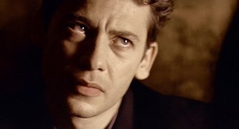 Movie still from “Lock, Stock and Two Smoking Barrels” (1998), directed by Guy Ritchie – A man's face in a dark room; Close Up shot, Low angle
