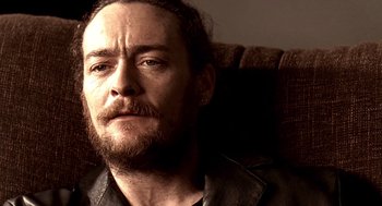 Movie still from “Lock, Stock and Two Smoking Barrels” (1998), directed by Guy Ritchie – A person with a beard; Close Up shot, Over the shoulder angle