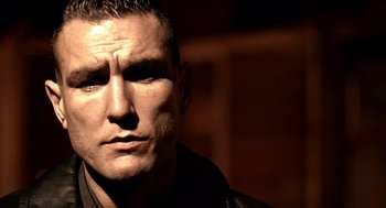Movie still from “Lock, Stock and Two Smoking Barrels” (1998), directed by Guy Ritchie – A man's face in a dark room; Close Up shot, Low angle