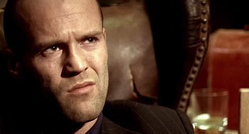 Movie still from “Lock, Stock and Two Smoking Barrels” (1998), directed by Guy Ritchie – A person wearing a suit and tie; Close Up shot, Low angle