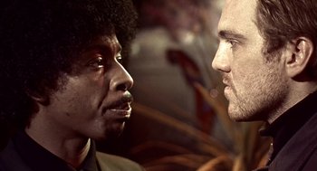 Movie still from “Lock, Stock and Two Smoking Barrels” (1998), directed by Guy Ritchie – Two men face each other in a close up picture; Close Up shot, Low angle