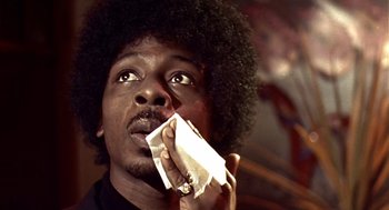 Movie still from “Lock, Stock and Two Smoking Barrels” (1998), directed by Guy Ritchie – A man holding a piece of paper in front of his face; Close Up shot, Low angle