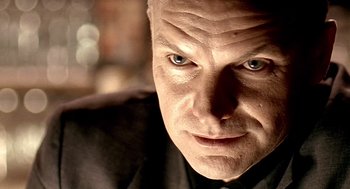 Movie still from “Lock, Stock and Two Smoking Barrels” (1998), directed by Guy Ritchie – A man's face in a black shirt; Extreme Close Up shot, Low angle