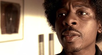 Movie still from “Lock, Stock and Two Smoking Barrels” (1998), directed by Guy Ritchie – A man's face in front of a window; Close Up shot, Low angle