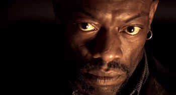 Movie still from “Lock, Stock and Two Smoking Barrels” (1998), directed by Guy Ritchie – A man's face in the dark; Close Up shot, Low angle