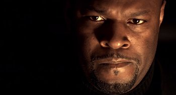 Movie still from “Lock, Stock and Two Smoking Barrels” (1998), directed by Guy Ritchie – A man's face in the dark; Extreme Close Up shot, Low angle