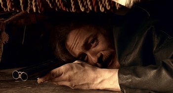 Movie still from “Lock, Stock and Two Smoking Barrels” (1998), directed by Guy Ritchie – A person laying on the ground; Close Up shot, High angle