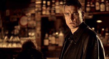 Movie still from “Lock, Stock and Two Smoking Barrels” (1998), directed by Guy Ritchie – A person in a bar; Close Up shot, Low angle