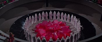 Movie still from “Logan's Run” (1976), directed by Michael Anderson – A group of people standing in front of a large red object; Extreme Wide shot, High angle