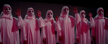 Movie still from “Logan's Run” (1976), directed by Michael Anderson – A group of people dressed in white and wearing masks; Medium shot, Low angle