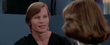 Movie still from “Logan's Run” (1976), directed by Michael Anderson – A man in black shirt talking to another man in black shirt; Close Up shot, Over the shoulder angle