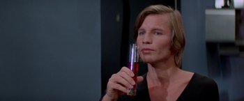 Movie still from “Logan's Run” (1976), directed by Michael Anderson – A woman holding a glass of liquid in her hand; Close Up shot, Over the shoulder angle