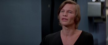 Movie still from “Logan's Run” (1976), directed by Michael Anderson – A person with long blonde hair; Close Up shot, Over the shoulder angle