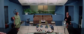 Movie still from “Logan's Run” (1976), directed by Michael Anderson – A living room filled with furniture next to plants; Extreme Wide shot, High angle