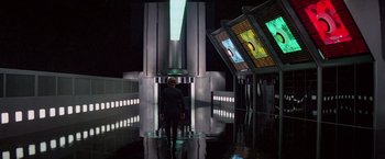 Movie still from “Logan's Run” (1976), directed by Michael Anderson – A man standing in front of a large clock tower; Wide shot, Low angle
