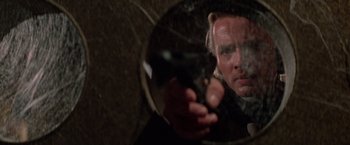 Movie still from “Logan's Run” (1976), directed by Michael Anderson – A man holding a gun in front of a mirror; Close Up shot, Low angle