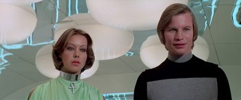 Movie still from “Logan's Run” (1976), directed by Michael Anderson – A woman and a man standing next to each other in a room; Close Up shot, Low angle
