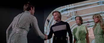 Movie still from “Logan's Run” (1976), directed by Michael Anderson – Two men shake hands in front of a mirror; Medium shot, Over the shoulder angle