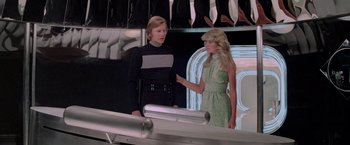 Movie still from “Logan's Run” (1976), directed by Michael Anderson – A man and a woman are standing in front of a neon sign; Medium shot, Low angle