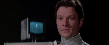 Movie still from “Logan's Run” (1976), directed by Michael Anderson – A person wearing a silver shirt; Close Up shot, Low angle