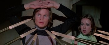Movie still from “Logan's Run” (1976), directed by Michael Anderson – A person holding their hands over their head; Close Up shot, Overhead angle