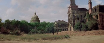 Movie still from “Logan's Run” (1976), directed by Michael Anderson – Two people standing in front of a building in a field; Extreme Wide shot, Low angle