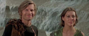 Movie still from “Logan's Run” (1976), directed by Michael Anderson – A man and a woman standing next to each other near a waterfall; Close Up shot, Low angle