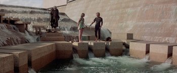 Movie still from “Logan's Run” (1976), directed by Michael Anderson – Two young people standing on blocks near a waterfall; Wide shot, High angle