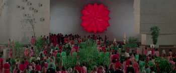 Movie still from “Logan's Run” (1976), directed by Michael Anderson – A crowd of people standing in front of a large red flower; Extreme Wide shot, High angle