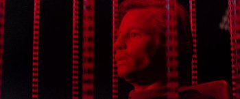 Movie still from “Logan's Run” (1976), directed by Michael Anderson – A man is looking into the distance in a red light; Close Up shot, Low angle