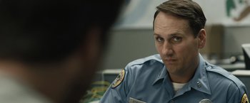 A man in a uniform is looking at the camera