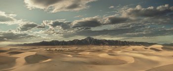 Movie still from “Loki” (2021), created by Michael Waldron – A view of a desert landscape with mountains in the background; Extreme Wide shot, High angle