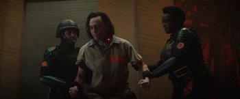 Movie still from “Loki” (2021), created by Michael Waldron – A group of people that are standing in a room together; Medium shot, Over the shoulder angle