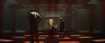 Movie still from “Loki” (2021), created by Michael Waldron – Two men standing in front of a projection screen; Medium shot, Over the shoulder angle