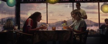 Movie still from “Loki” (2021), created by Michael Waldron – Two women sitting at a table eating food; Medium shot, Over the shoulder angle