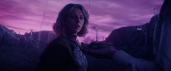 Movie still from “Loki” (2021), created by Michael Waldron – A woman standing in front of a purple sky; Medium shot, Over the shoulder angle