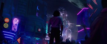 Movie still from “Loki” (2021), created by Michael Waldron – A person standing in a city at night; Wide shot, Low angle