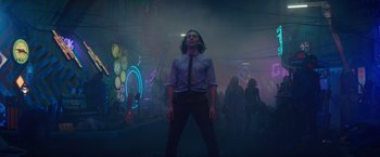 Movie still from “Loki” (2021), created by Michael Waldron – A man standing in the middle of a room with neon lights; Wide shot, Low angle