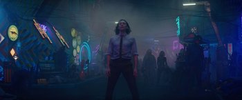 Movie still from “Loki” (2021), created by Michael Waldron – A man standing in the middle of a room with neon lights in the background; Wide shot, Low angle