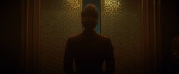 Movie still from “Loki” (2021), created by Michael Waldron – A man standing in front of a wall; Close Up shot, Low angle