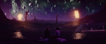 Movie still from “Loki” (2021), created by Michael Waldron – Two people sitting on rocks in front of a body of water; Extreme Wide shot, Over the shoulder angle