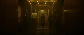 Movie still from “Loki” (2021), created by Michael Waldron – A group of people standing in front of an elevator; Wide shot, Low angle