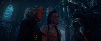 Movie still from “Loki” (2021), created by Michael Waldron – A man and a woman standing next to each other; Medium shot, Low angle