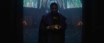 Movie still from “Loki” (2021), created by Michael Waldron – A man in a purple robe holding something in his hand; Medium shot, Low angle