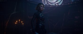 Movie still from “Loki” (2021), created by Michael Waldron – A woman holding a sword while standing in front of a wall; Medium shot, Over the shoulder angle