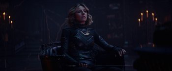 Movie still from “Loki” (2021), created by Michael Waldron – A woman sitting in a chair in a dark room; Medium shot, Over the shoulder angle