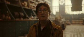 Movie still from “Loki” (2021), created by Michael Waldron – A man with glasses is looking at the camera; Close Up shot, Over the shoulder angle